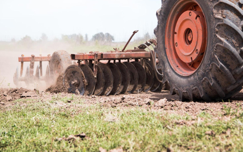 Gran tractor equipado con neumáticos de gran huella dedicados al cultivo de tierras.